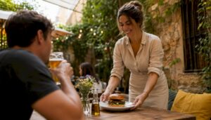 Una camarera entrega una hamburguesa gourmet a un cliente en el restaurante.