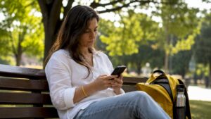 Una mujer realiza una reserva de mesa desde su teléfono móvil.