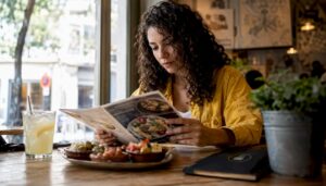 Un cliente hojea la carta del restaurante buscando qué hamburguesa pedir.