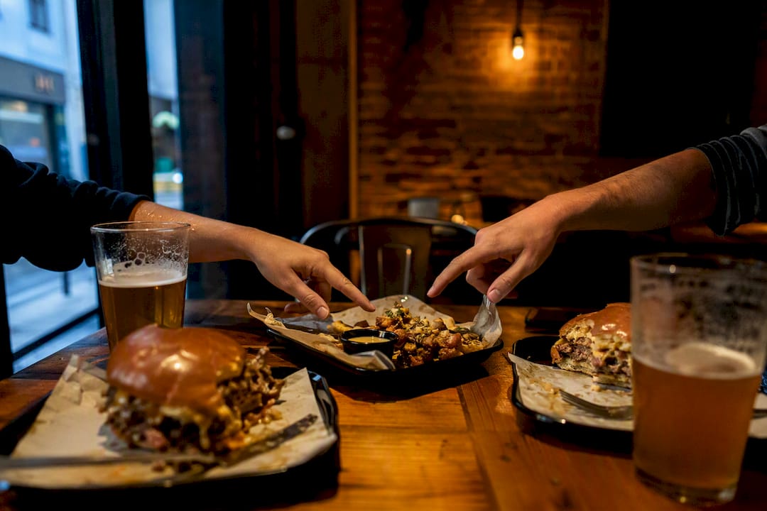 Ambiente nocturno en un bar de hamburguesas con platos de comida