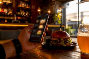 Persona consultando el menú digital del restaurante desde su móvil