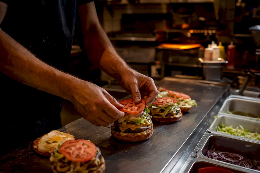 Chef preparando hamburguesas en la cocina del bar