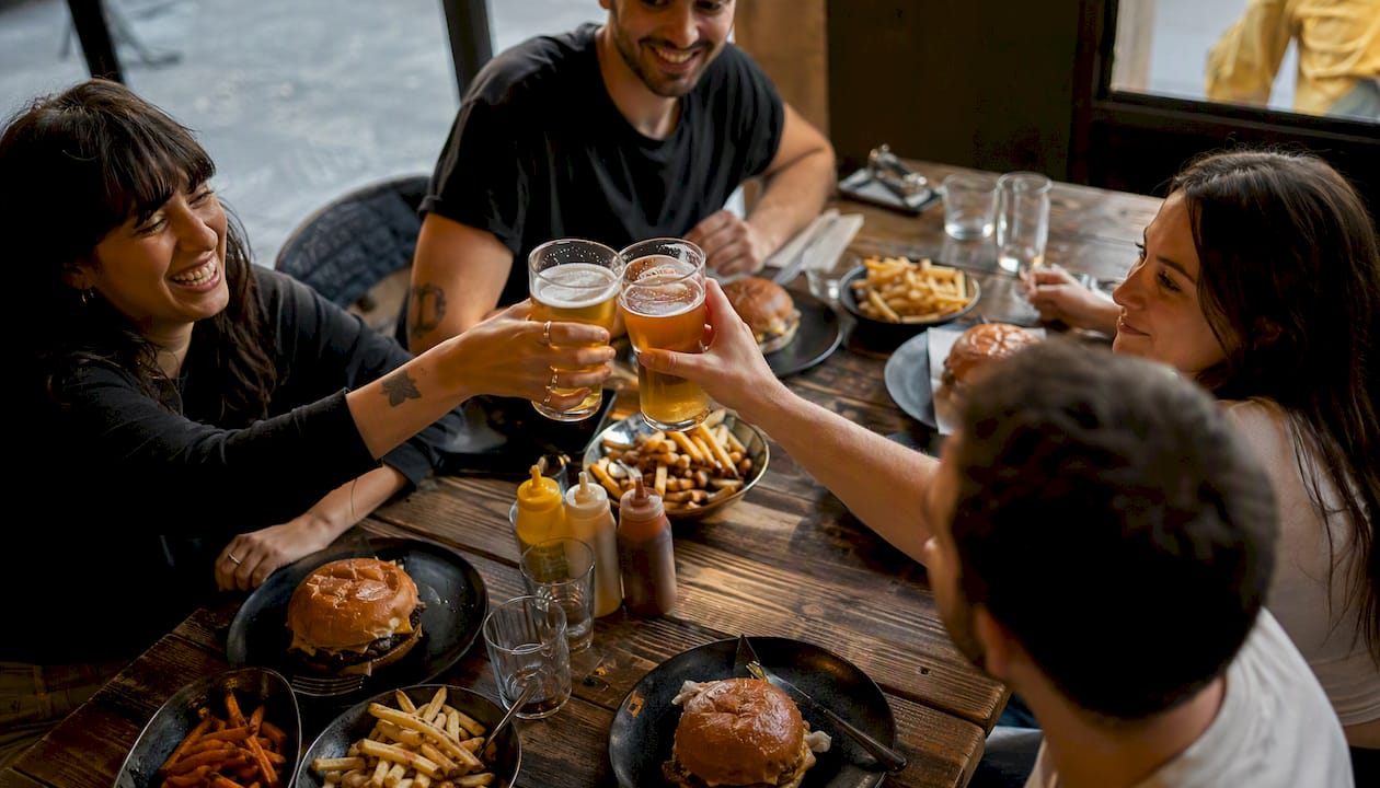 Sirviendo una cerveza artesanal bien fría durante una comida informal de domingo entre amigos.