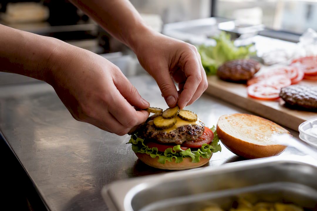 Cocinero elaborando una hamburguesa gourmet a mano