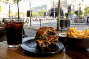 Hamburguesa artesanal con papas fritas sobre mesa de madera
