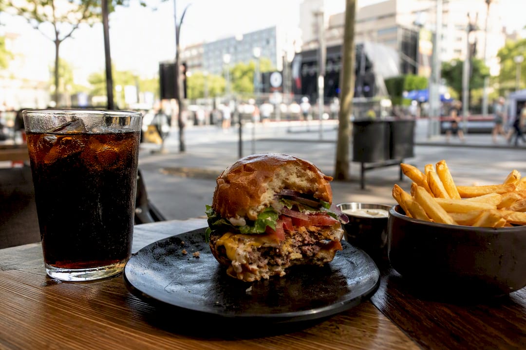 Hamburguesa artesanal con papas fritas sobre mesa de madera