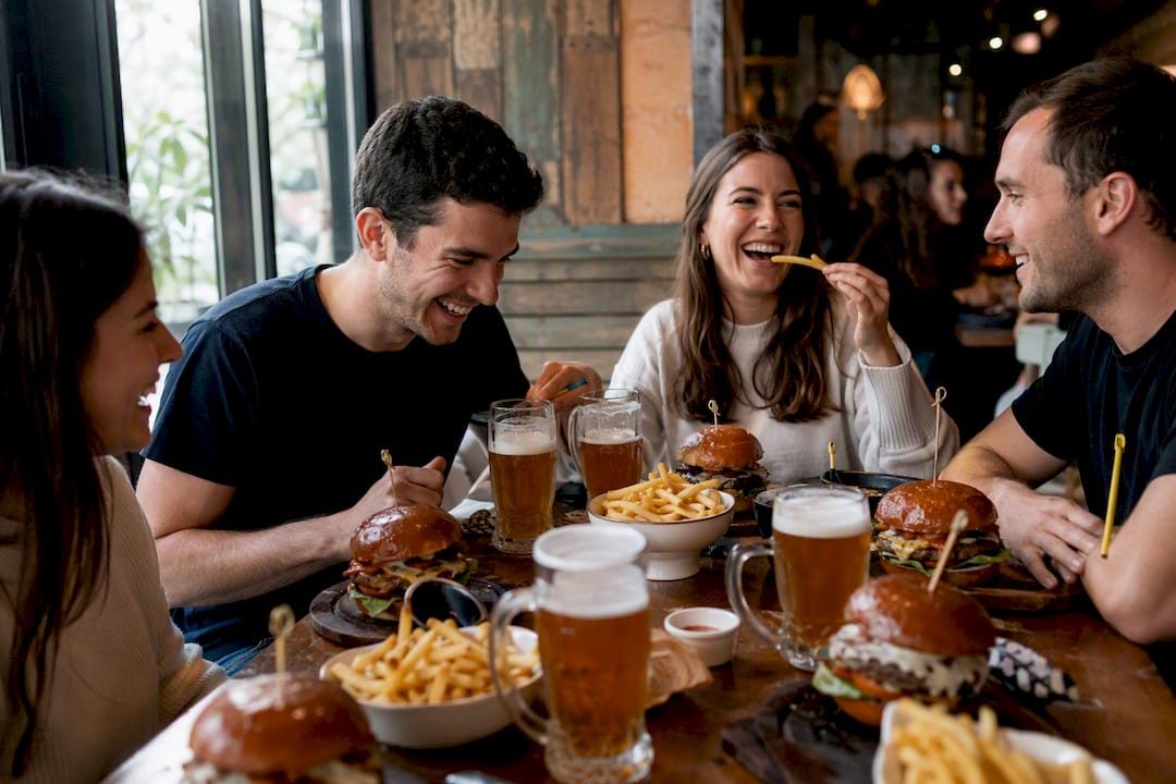 Mesa informal en bar de hamburguesas con comida y bebidas