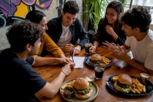 Manos dividiendo la cuenta en la mesa de una hamburguesería