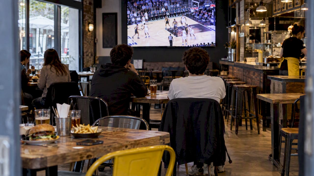 Un grupo de amigos disfruta viendo baloncesto en un bar casual