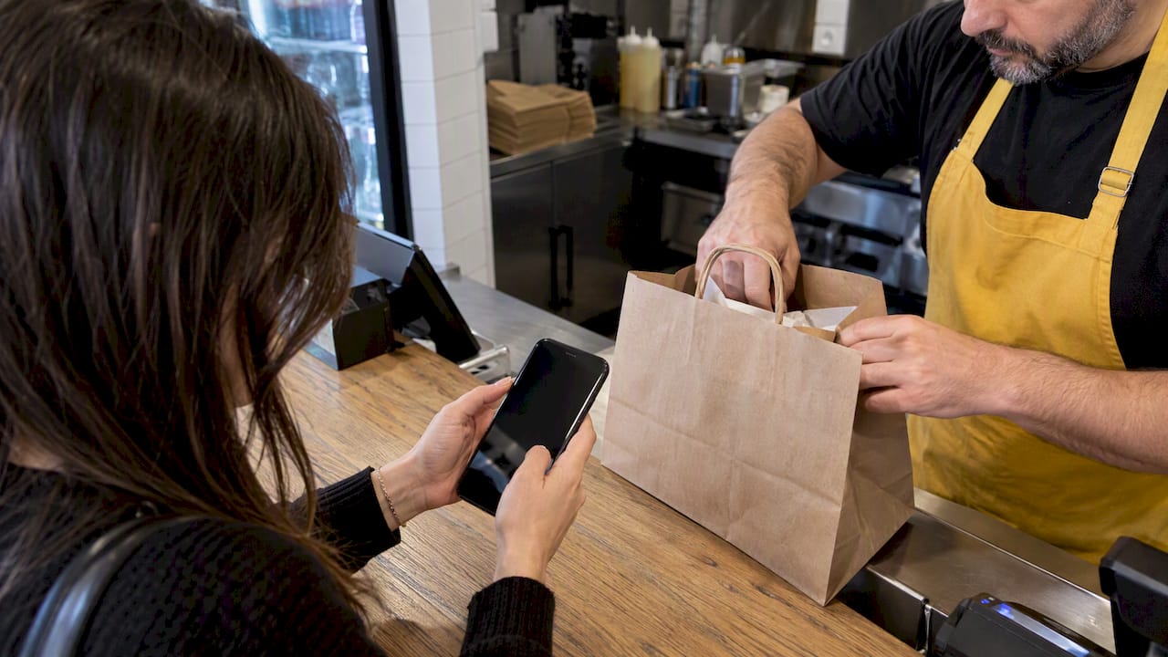 Cliente mostrando el pedido en su móvil