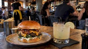 Hamburguesa artesanal servida con un cóctel